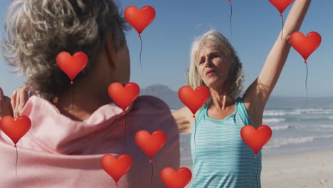 Animation-Von-Roten-Herzballons-über-Frauen,-Die-Am-Strand-Trainieren