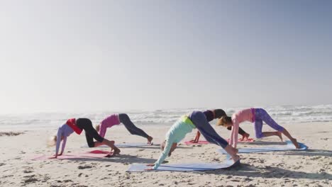 Animation-of-text-vibes,-in-white-and-black,-over-women-exercising-on-beach