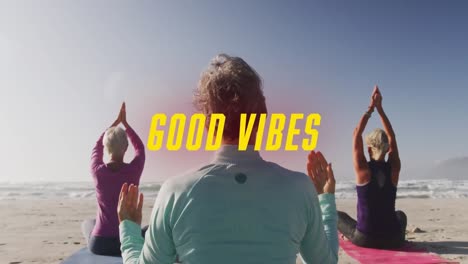 Animation-of-text-good-vibes,-in-yellow,-with-women-doing-yoga-sitting-on-beach