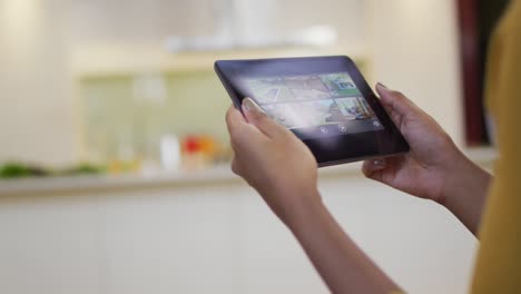 Mixed-race-woman-using-tablet-in-kitchen
