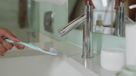 Mid-section-view-of-mixed-race-woman-holding-toothbrush
