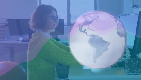 Animation-of-globe-over-business-woman-using-computer