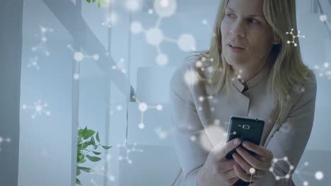 Animation-of-molecules-over-businesswoman-using-smartphone
