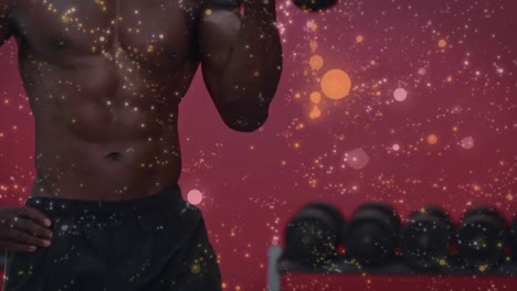 Animation-of-glowing-spots-over-strong-muscular-man-lifting-dumbbells