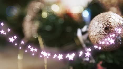 Animation-of-star-string-lights-and-blurred-christmas-tree-decorations