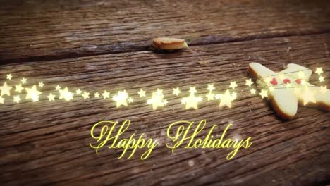 Animation-of-text,-happy-holidays,-in-yellow,-over-string-lights-and-falling-gingerbread-man