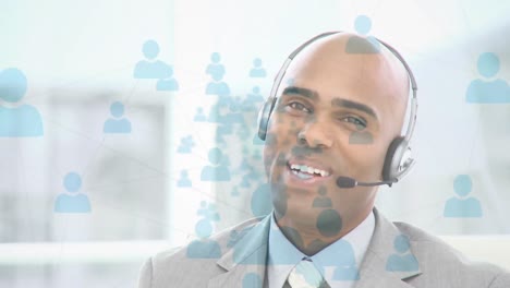 Animation-of-network-of-connection-with-icons-over-businessman-wearing-phone-headset