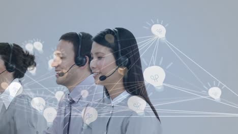 Animation-of-network-of-connection-with-icons-over-business-people-wearing-phone-headsets