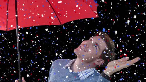 Animation-of-blue-red-and-white-confetti-over-man-holding-umbrella-on-black-background