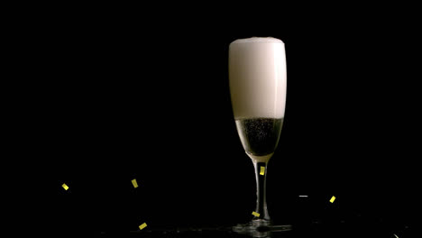 Animation-of-gold-confetti-falling-over-glass-of-champagne