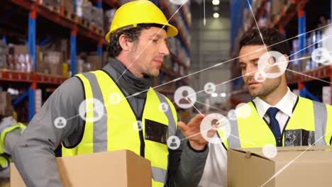 Animation-of-network-of-people-icons-over-two-male-staff-talking-at-storage-warehouse