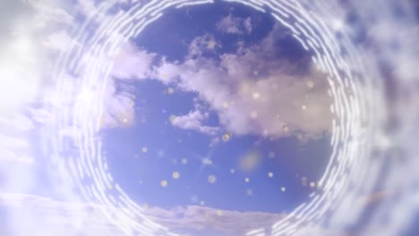 Animation-of-rotating-rings-and-sparkles-over-bright-cloudy-blue-sky