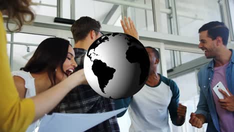 Animation-of-rotating-globe-over-happy-diverse-colleagues-celebrating-at-casual-office-meeting