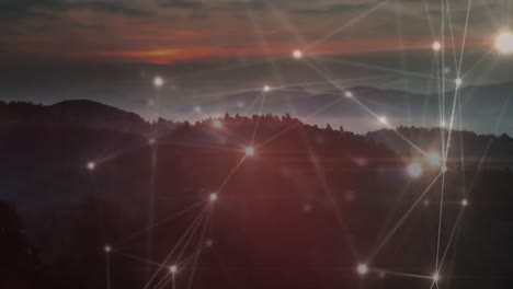 Animation-of-glowing-network-of-connections-moving-over-sunset-landscape