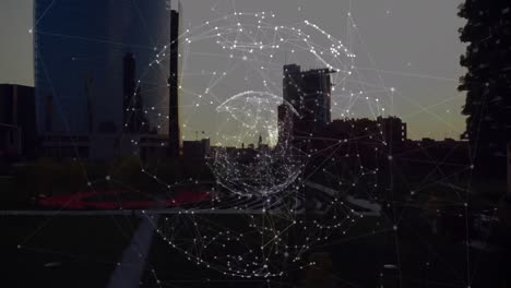 Animation-of-global-network-of-connections-rotating-over-city-at-sunset
