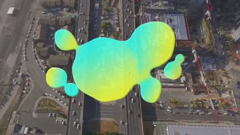 Animation-of-green-and-yellow-blot-moving-over-aerial-city-view