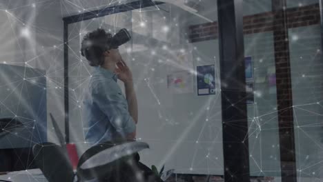 Animation-of-network-of-connections-over-businessman-using-vr-headset-in-office