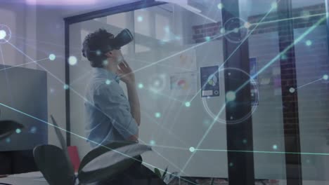 Animation-Eines-Netzwerks-Von-Verbindungen-über-Einem-Geschäftsmann,-Der-Im-Büro-Ein-VR-Headset-Verwendet