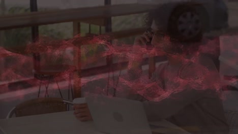 Animation-of-red-waves-over-businessman-in-office