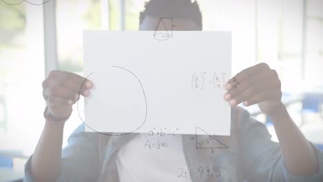 Ecuaciones-Matemáticas-Flotando-Contra-Un-Niño-Afroamericano-Sosteniendo-Un-Papel-En-La-Escuela-Primaria
