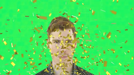 Golden-confetti-falling-over-portrait-of-caucasian-man-against-green-background