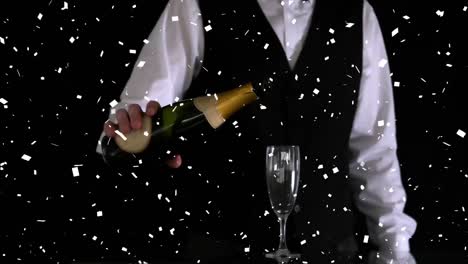 Paper-burning-and-confetti-falling-over-mid-section-of-bartender-pouring-champagne-into-a-glass