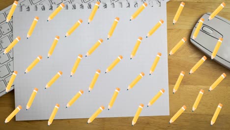 Animation-of-pencil-digital-icons-over-notebook-on-desk