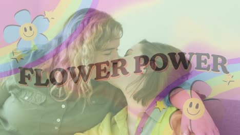 Animation-of-flower-power-text-with-rainbow-and-flowers-over-female-gay-couple-kissing