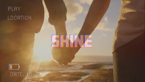 Animation-of-shine-text-on-video-camera-screen-with-digital-interface-with-couple-holding-hands