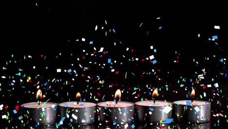 Digital-composition-ofcolorful-confetti-falling-over-burning-candles-against-black-background