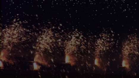 Animation-of-rows-of-fireworks-exploding-and-confetti-falling,-on-black
