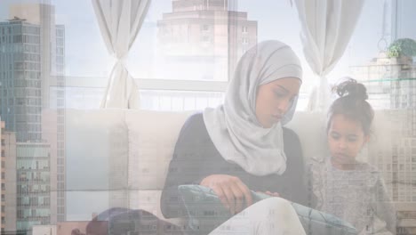 Animation-of-asian-mother-in-hijab-at-home-with-daughter-over-cityscape