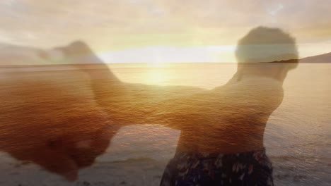 Animation-Eines-Afroamerikanischen-Paares,-Das-Sich-Bei-Sonnenuntergang-Am-Strand-über-Dem-Meer-Die-Hände-Hält