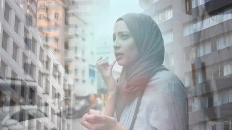 Animation-of-asian-woman-in-hijab-standing-in-city-over-cityscape