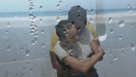 Animation-Eines-Glücklichen-Afroamerikanischen-Paares,-Das-Sich-Am-Strand-über-Tröpfchen-Umarmt