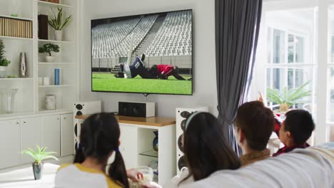 Zusammenstellung-Einer-Glücklichen-Familie,-Die-Zu-Hause-Zusammen-Sitzt-Und-Sich-Ein-Rugbyspiel-Im-Fernsehen-Ansieht