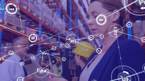 Animation-of-network-of-connections-with-icons-over-woman-with-tablet-working-in-warehouse