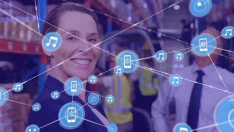 Animation-of-network-of-connections-with-icons-over-smiling-woman-working-in-warehouse
