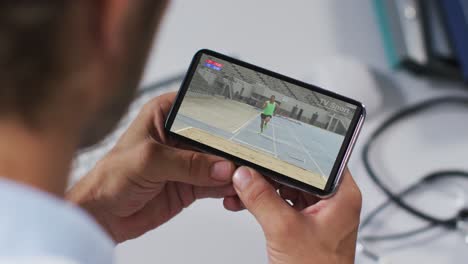 Composite-of-male-doctor-watching-athletics-long-jump-event-on-smartphone