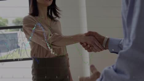 Statistical-data-processing-against-businessman-and-businesswoman-shaking-hands-at-office