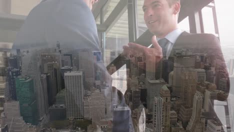 Digital-composition-of-two-caucasian-businessmen-shaking-hands-against-aerial-view-of-cityscape