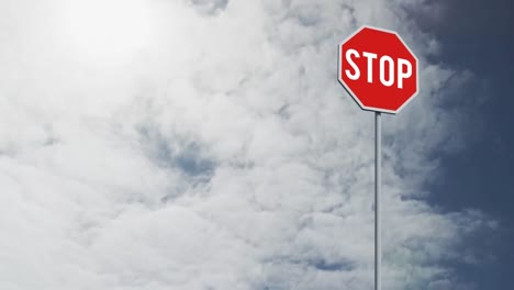 Signboard-post-with-stop-text-against-clouds-in-the-blue-sky