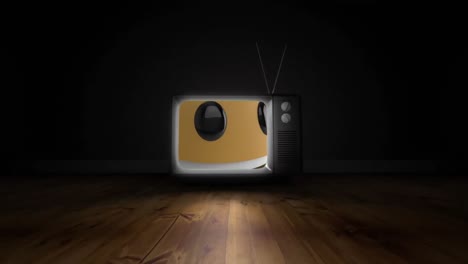 Smiling-face-emoji-on-television-screen-over-wooden-surface-against-black-background