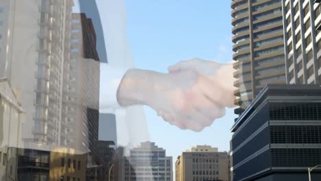 Mid-section-of-businessman-and-businesswoman-shaking-hands-against-tall-buildings-in-background