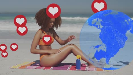 Globus-Und-Mehrere-Herzsymbole-Schweben-über-Einer-Afroamerikanerin,-Die-Am-Strand-Sonnencreme-Aufträgt