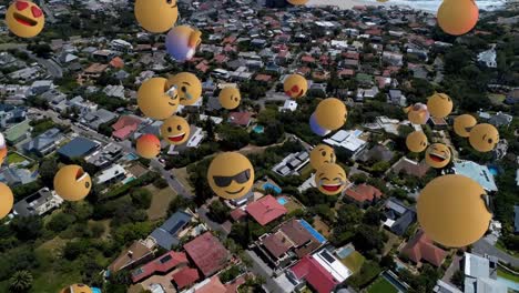 Digital-composition-of-multiple-face-emojis-floating-against-aerial-view-of-cityscape