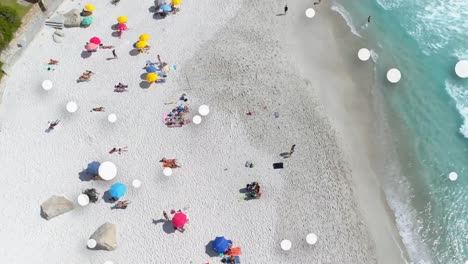 Digital-composition-of-multiple-white-spots-floating-against-aerial-view-of-the-beach