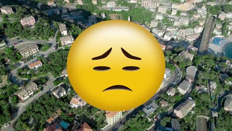 Angry-emotion-changing-to-sad-face-emoji-against-aerial-view-of-cityscape