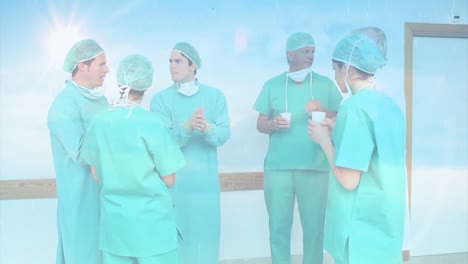 Digital-composition-of-spots-of-light-against-team-of-surgeons-discussing-together-at-hospital