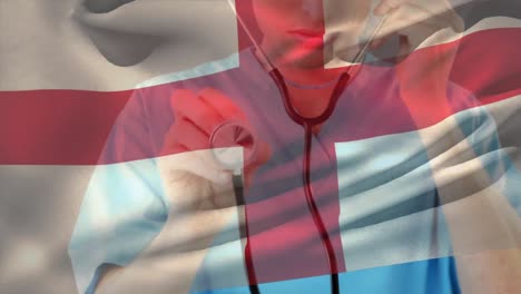 Digital-composition-of-england-flag-waving-over-caucasian-female-health-worker-holding-stethoscope
